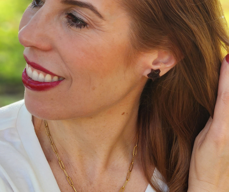 Sherami modelando los studs de estrella color vino de Sherami Collection. 