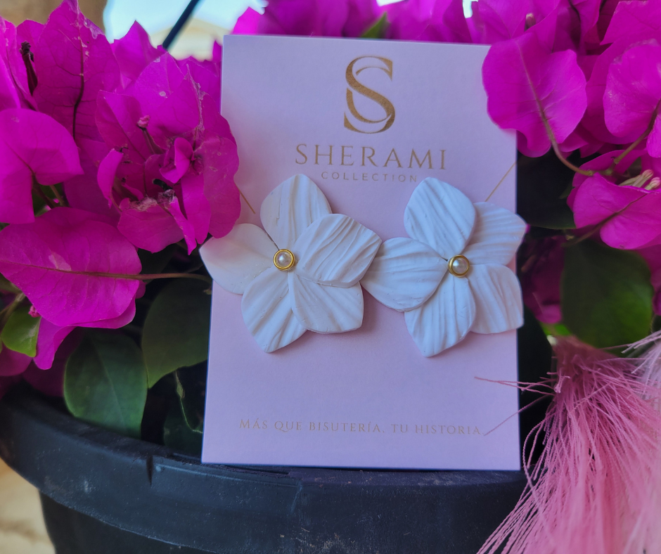 Aretes en forma de flor con textura y una perla en el centro.