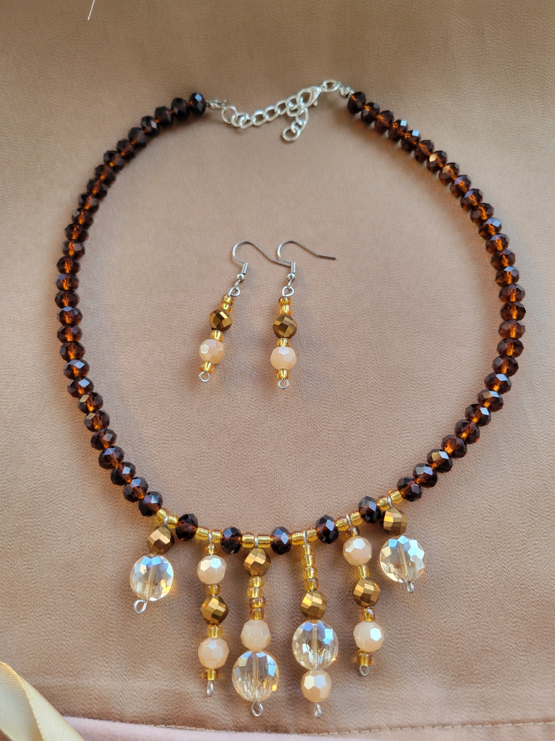 Conjunto de aretes y collar artesanal en color ambar y marrón de Sherami Collection.