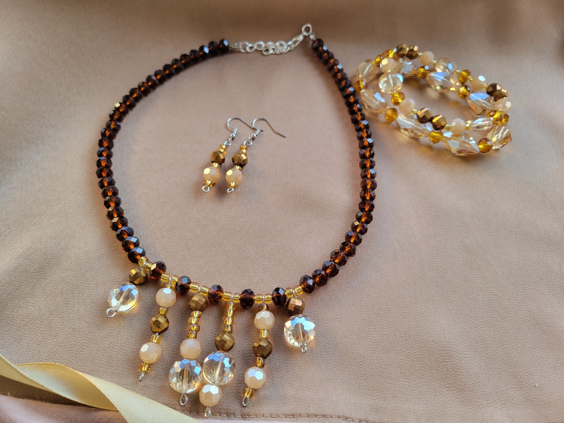 Conjunto de aretes y collar artesanal junto a pulseras artesanales de Sherami Collection