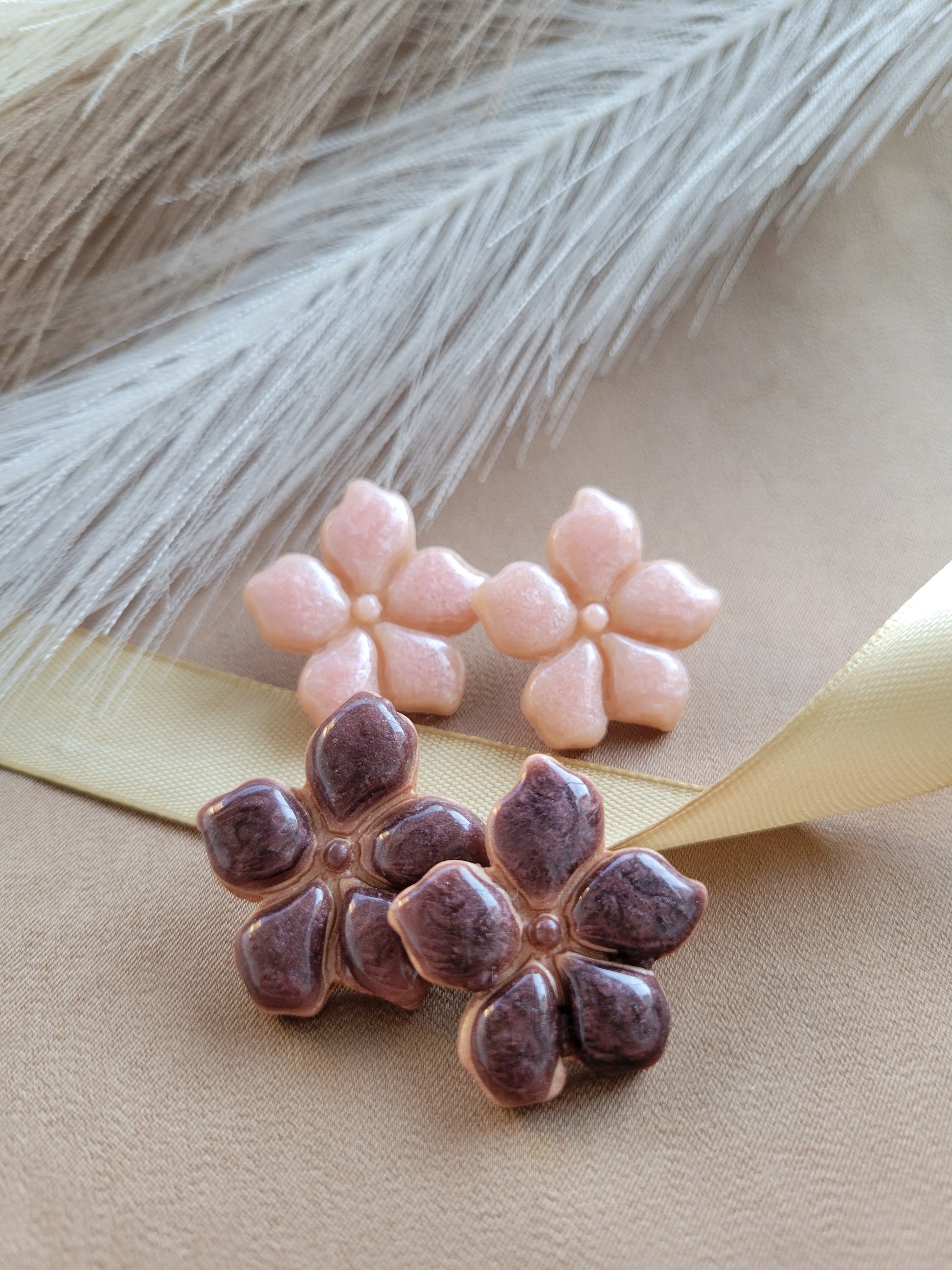 Dos pares de aretes artesanales de flores en color rosa y en color chocolate