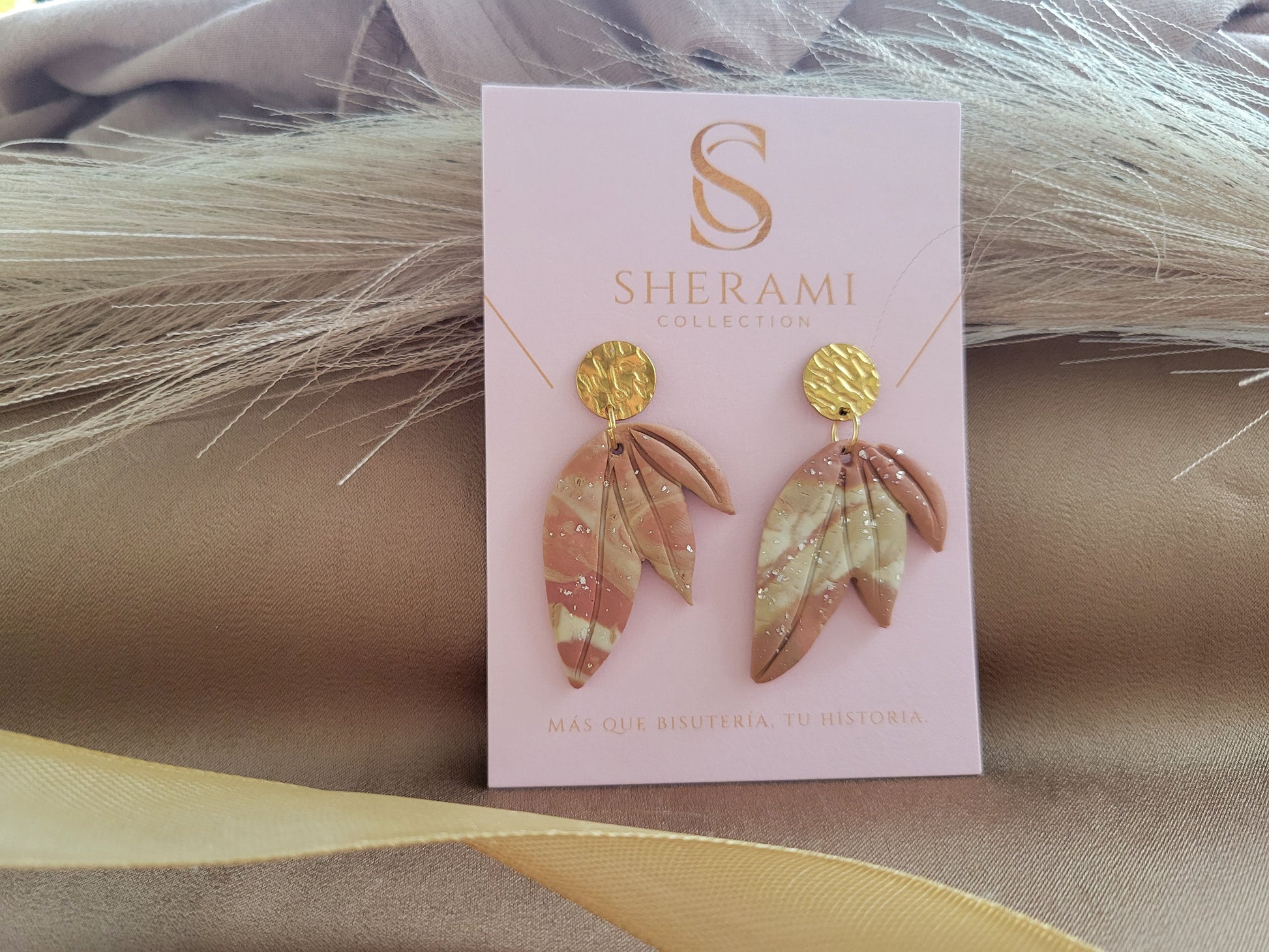 Decorative clay earrings on a Sherami Collection branded card 