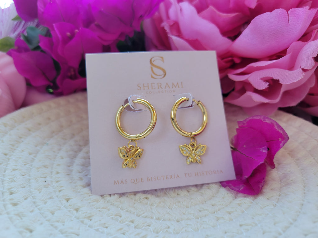 Aretes dorados tipo Huggies con colgante de mariposa 