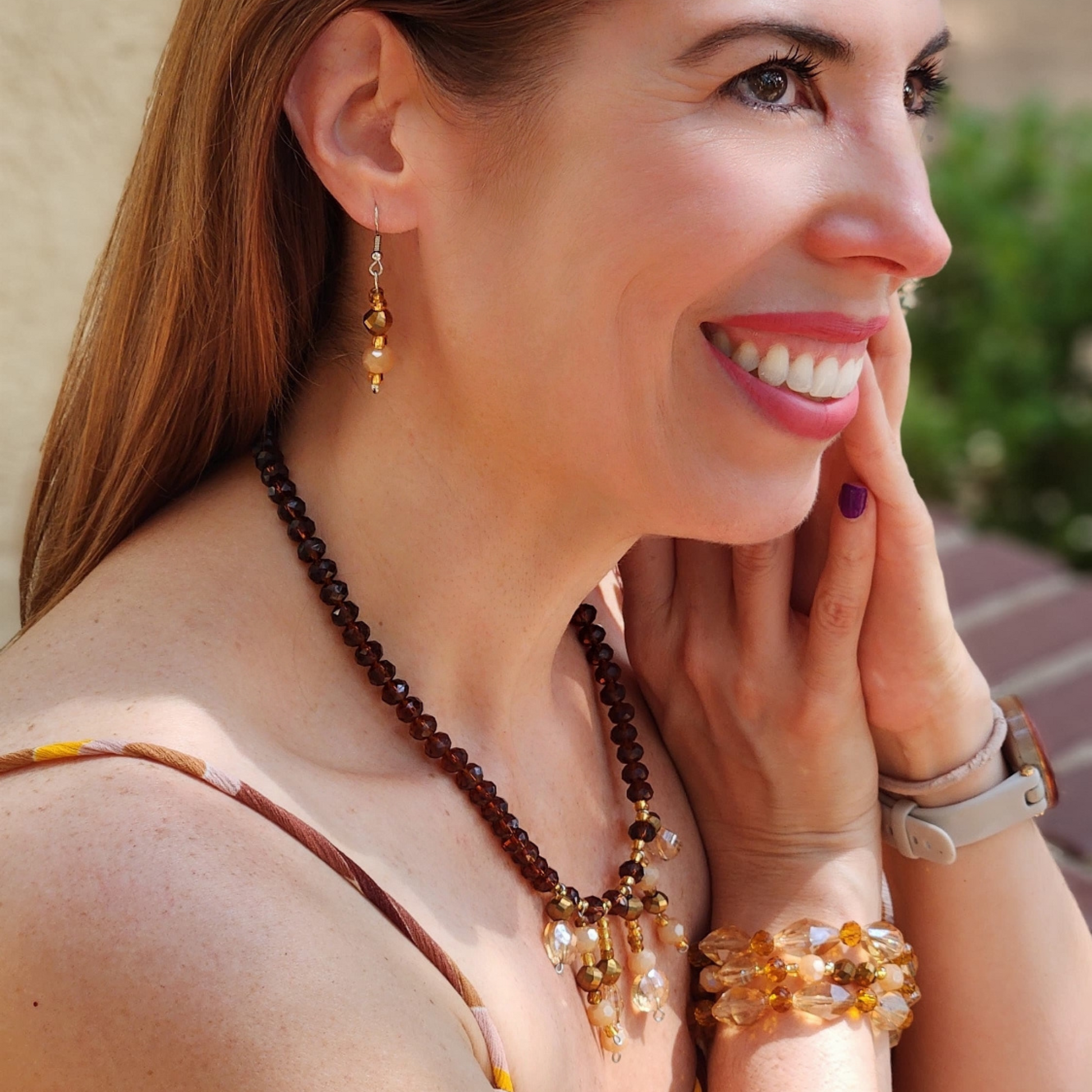 Mujer mostrando conjunto de collar y aretes artesanales de Sherami Collection