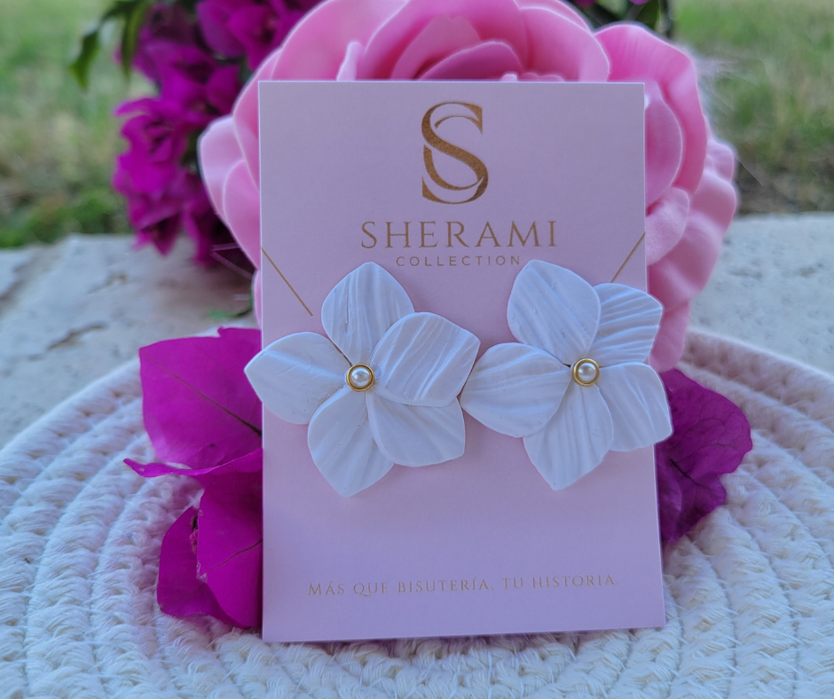 Aretes en forma de flor con textura y una perla en el centro.