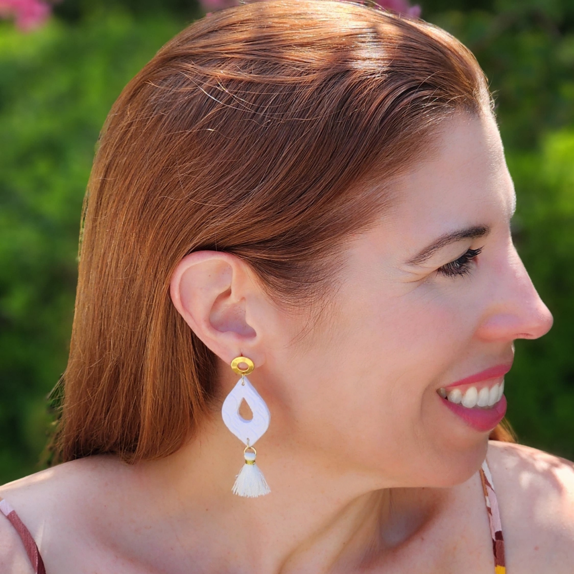 Mujer vistiendo aretes artesanales elegantes blancos de Sherami Collection