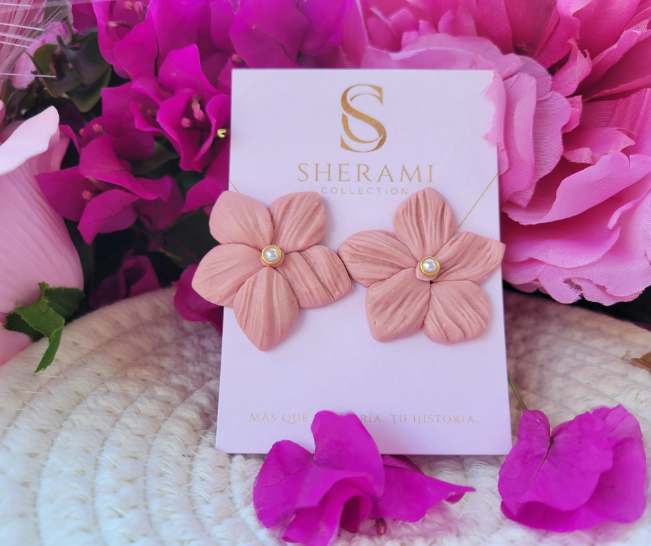 Aretes en forma de flor con textura y una perla en el centro.
