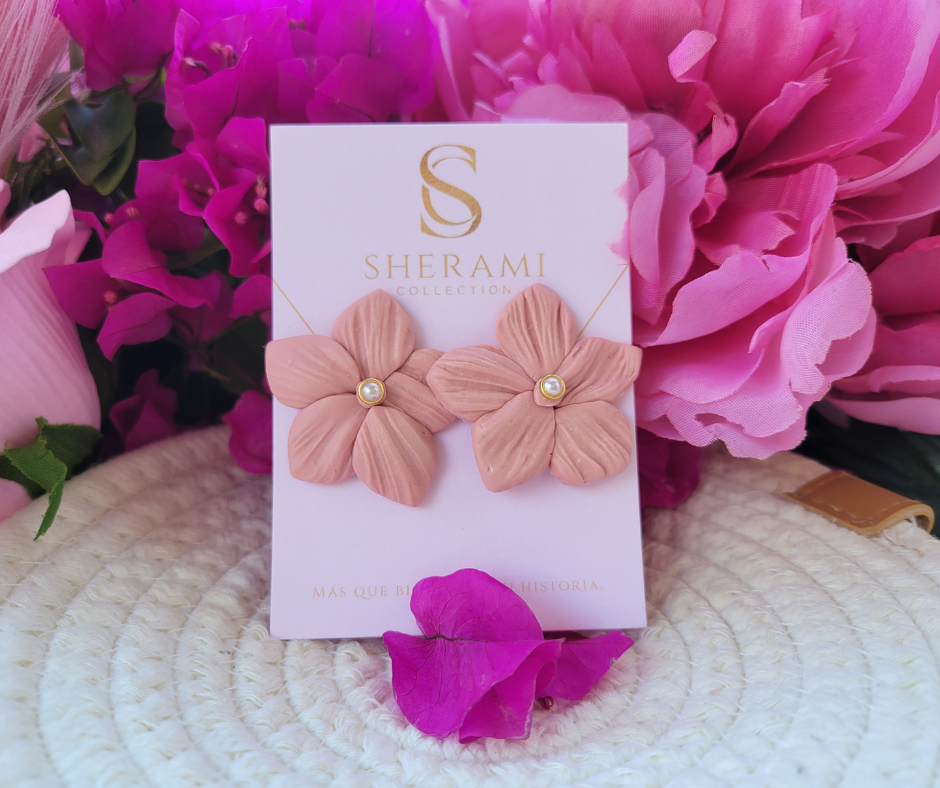 Aretes en forma de flor con textura y una perla en el centro.