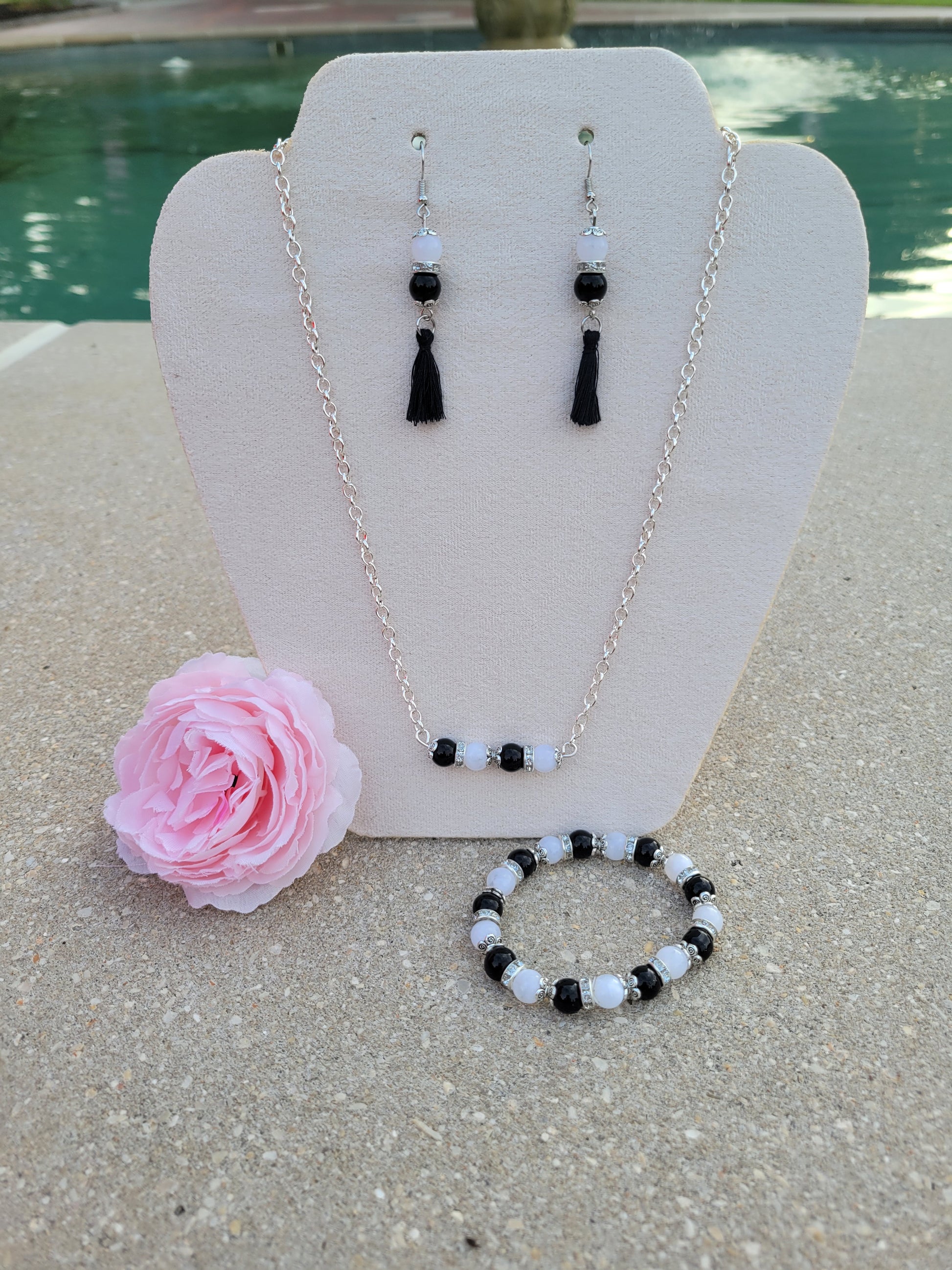 Set ded aretes, collar y pulsera en cuentas de cristal blancas y negras.