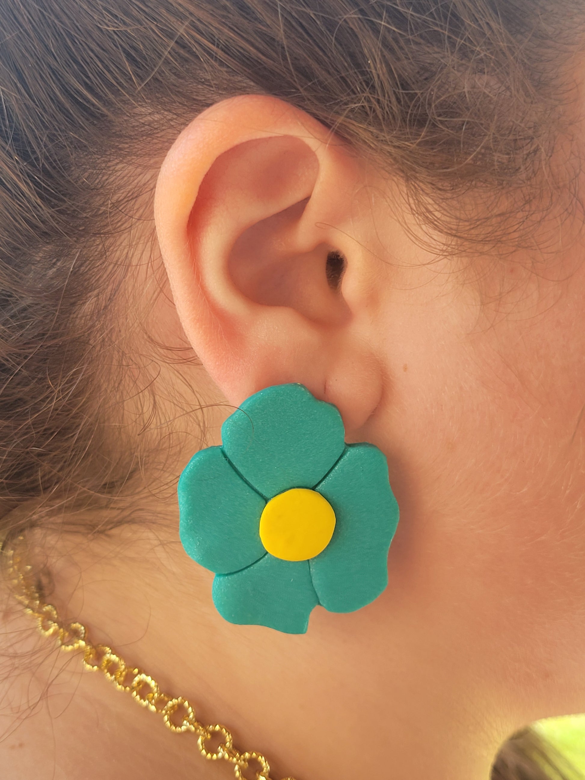 A woman wearing a blue flower shape earring by Sherami Collection