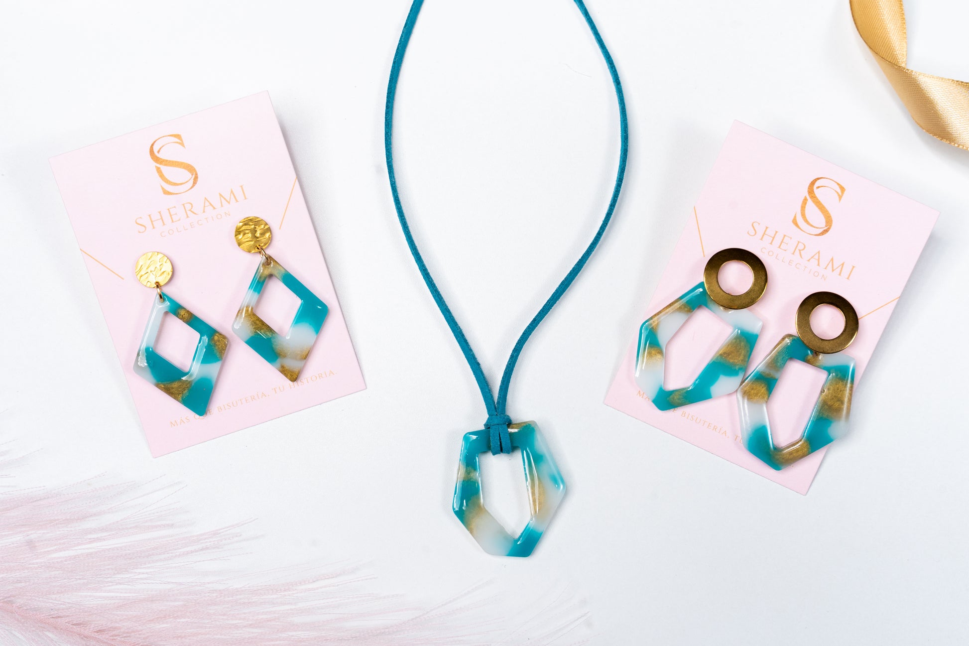 Necklace and earrings with blue, white and gold design on pink cards with 'Sherami Collection' branding.