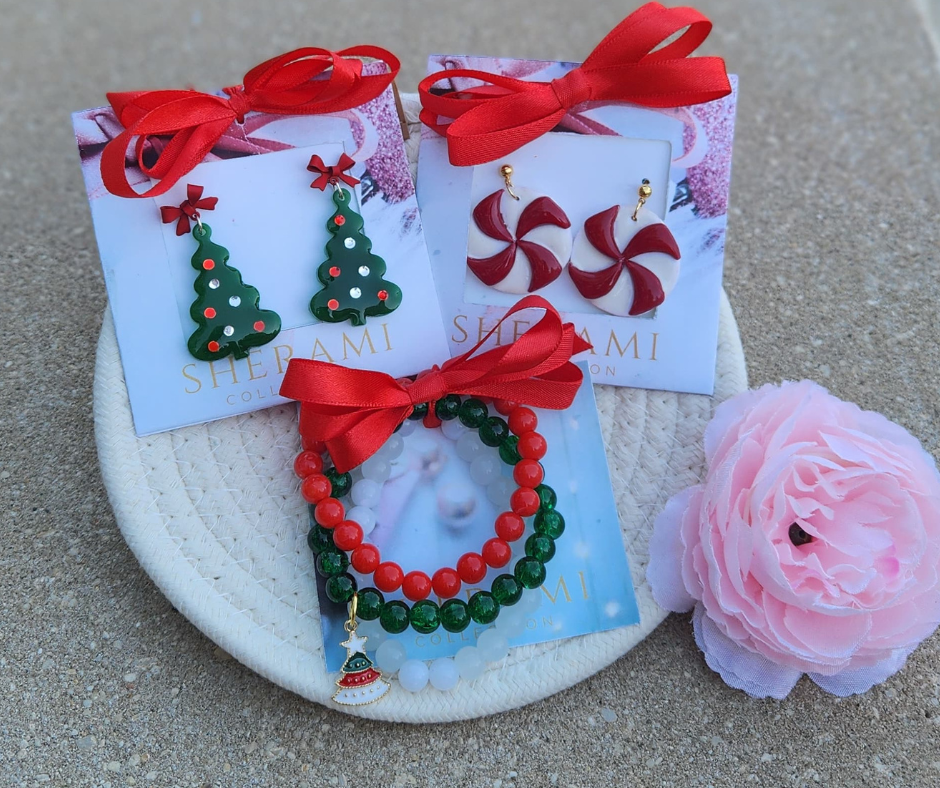 Primer plano del bundle navideño con sus tres productos, aretes de árbol de navidad, bombones de menta y stack de pulseras de Sherami Collection.