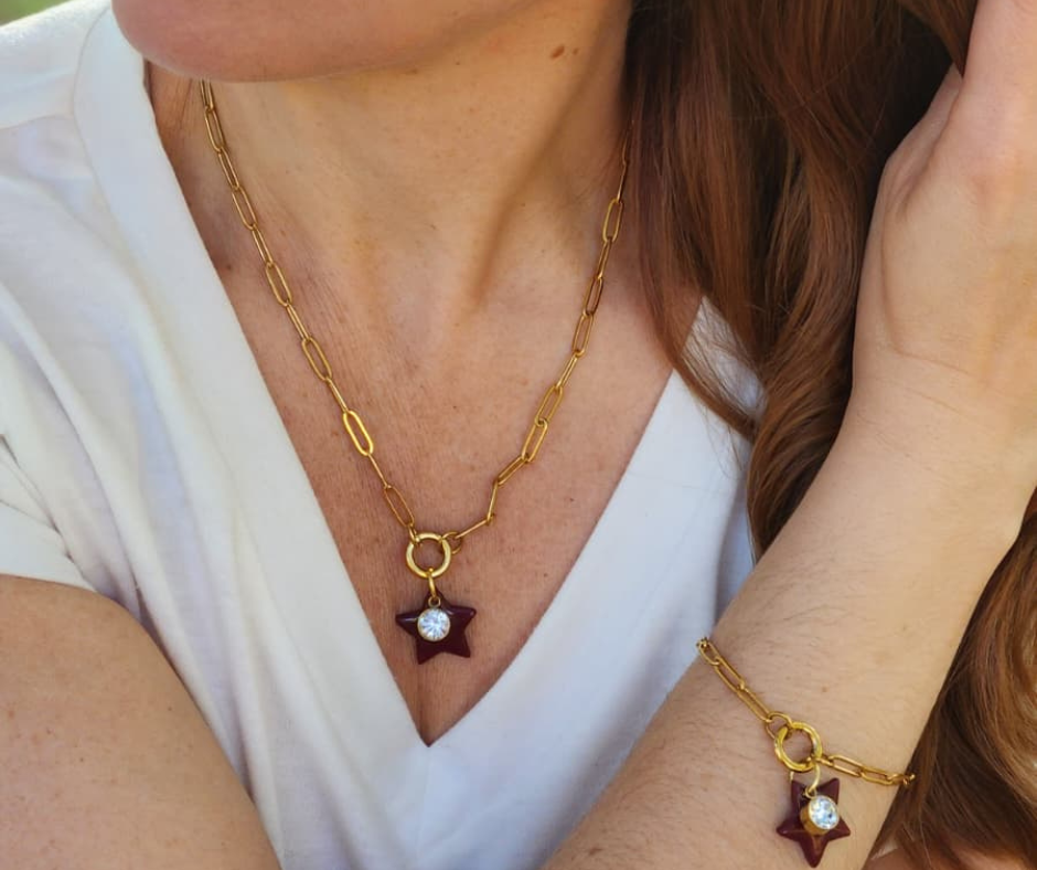 Primer plano del set  collar y pulsera Estrella de Belén en color vino y dorado. 