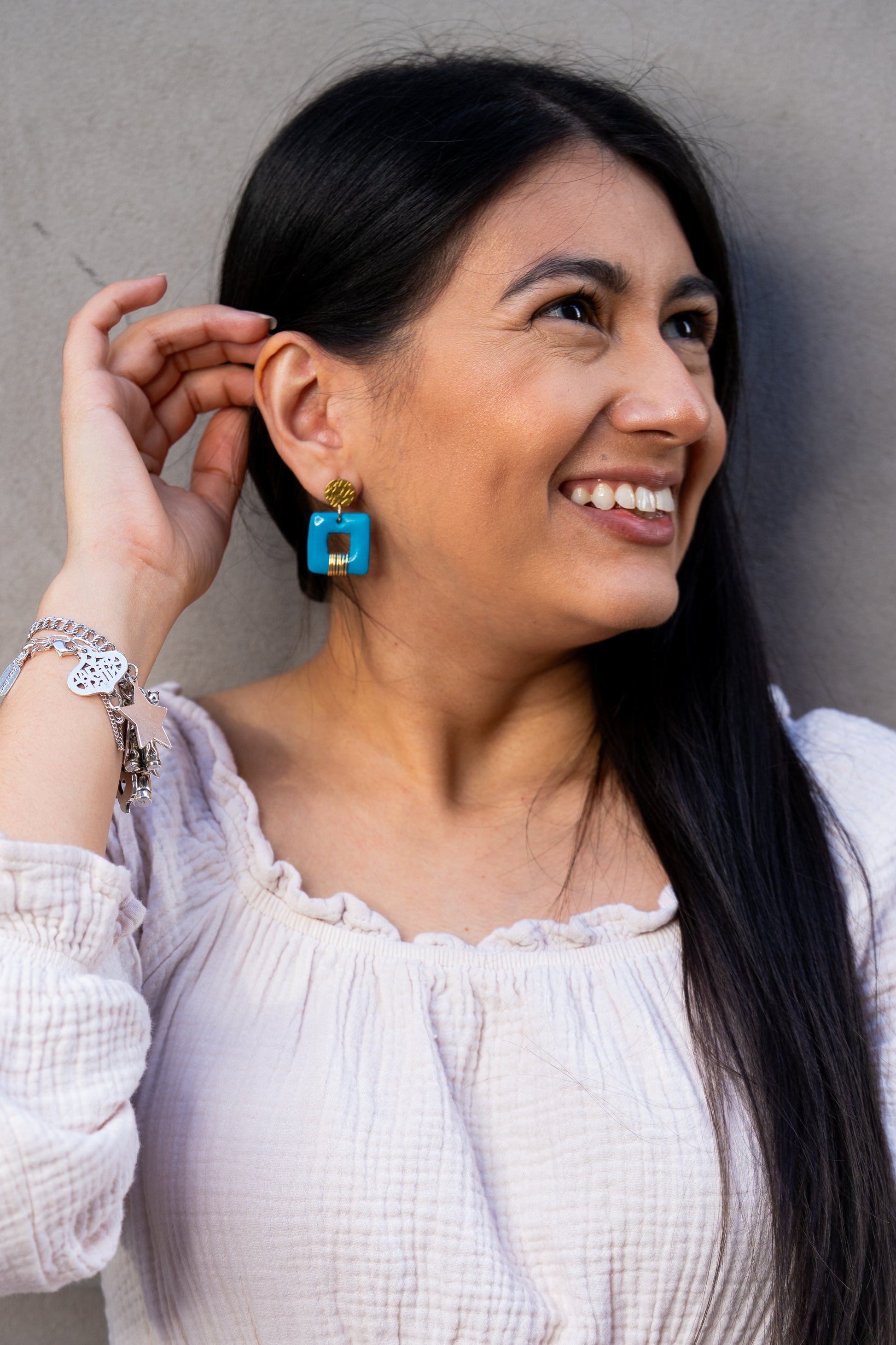 Modelo con los aretes Invitas en azul de Sherami Collection