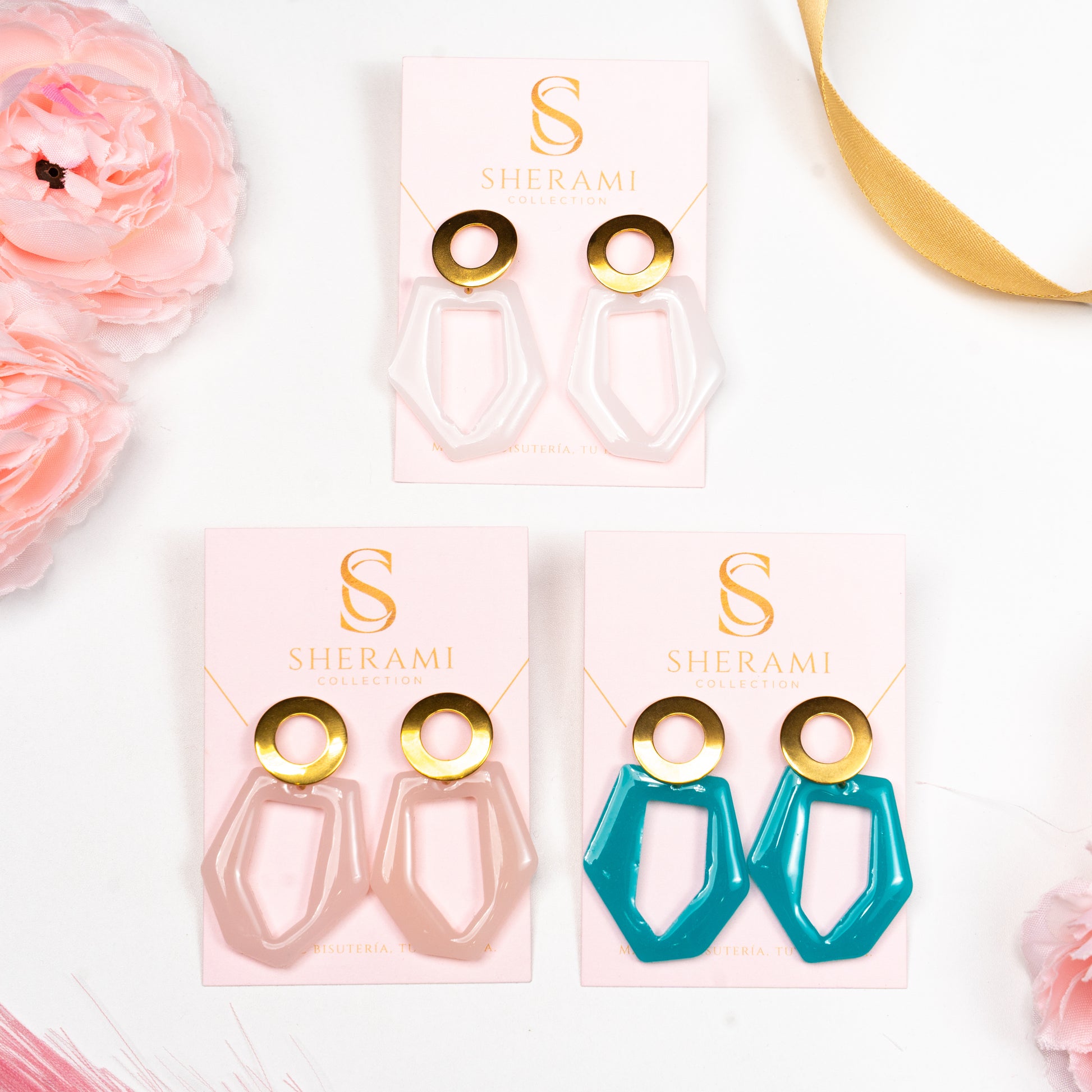 Three pairs of earrings in pink  packaging with 'SHERAMI Collection' branding on a white background.