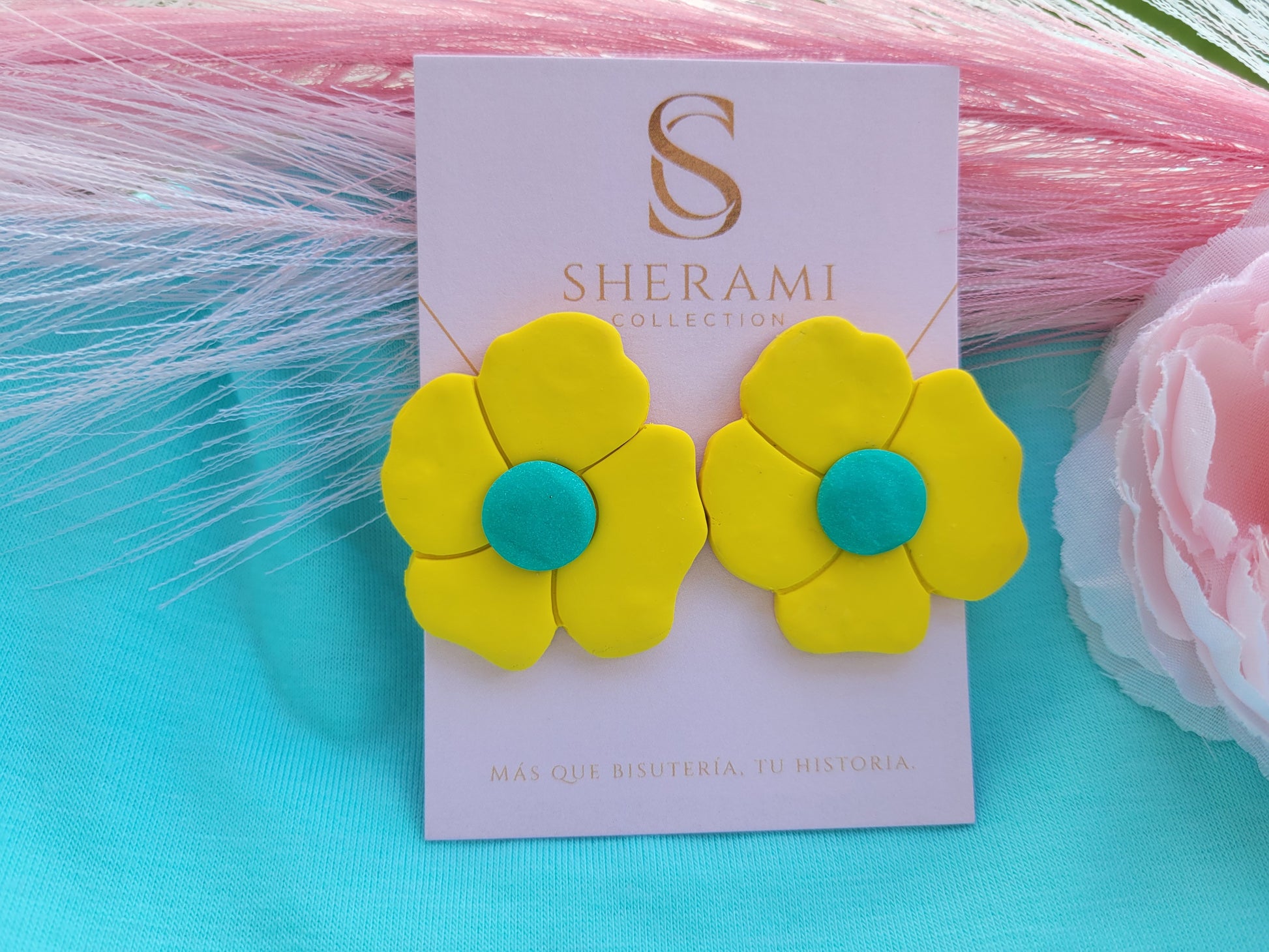 Pendientes en forma de flor amarilla con centros color turquesa sobre una tarjeta de la marca Sherami Collection.