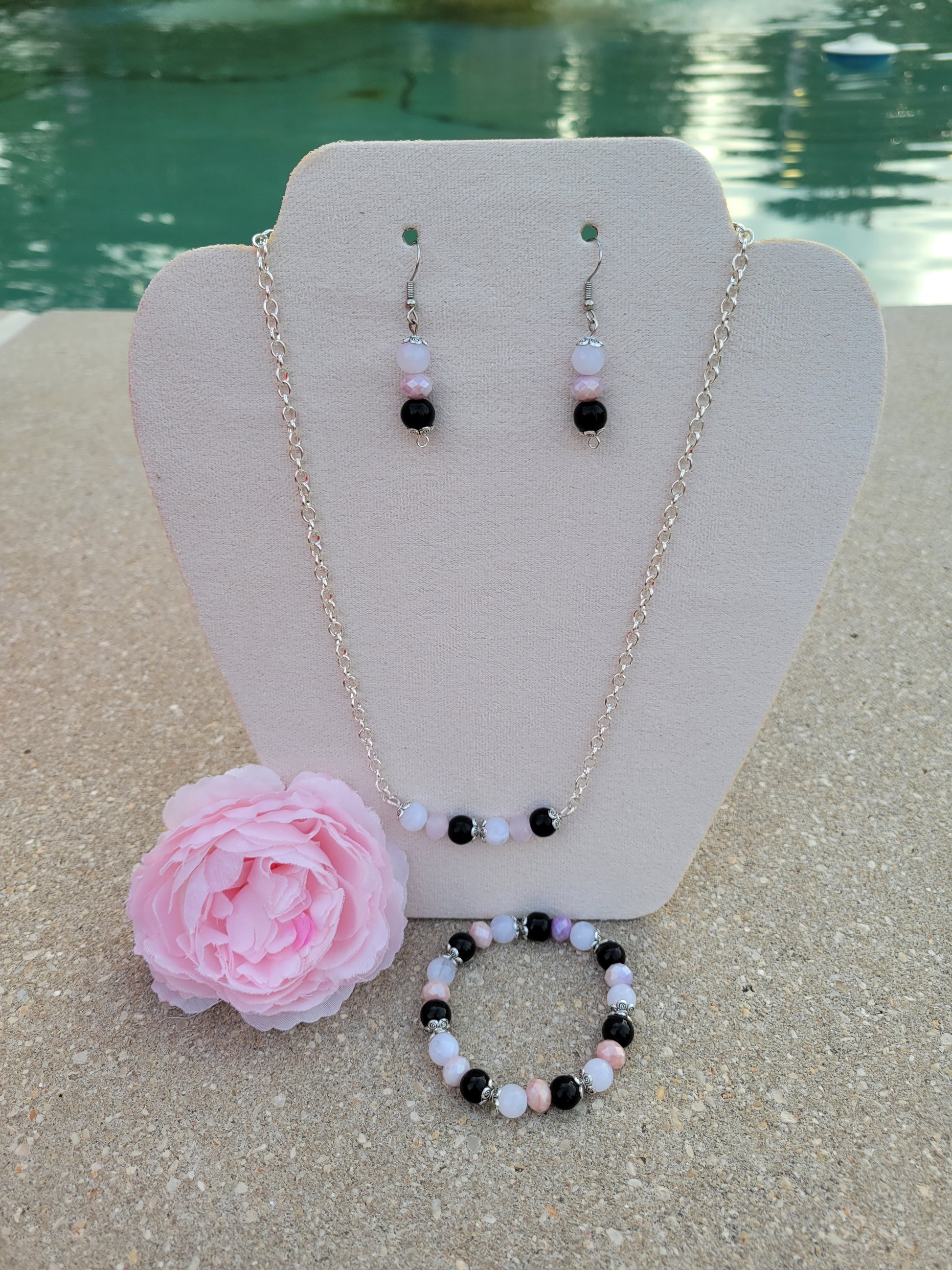 Se muestra set de collar con aretes t pulsera con cuentas de cristal.