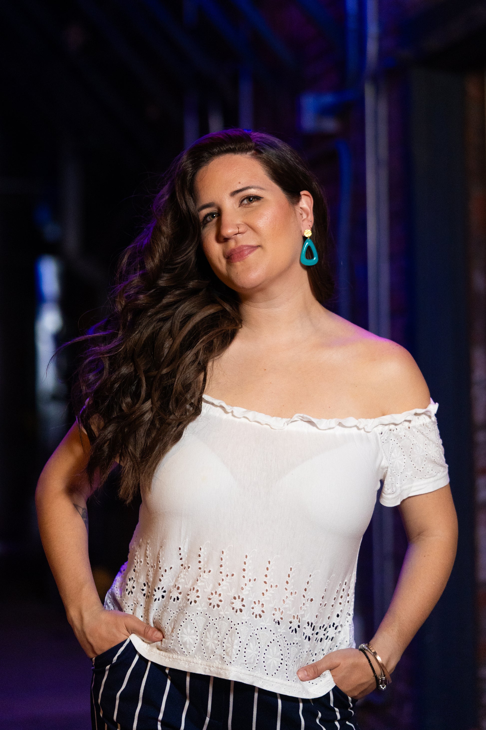 Woman wearing a white top  and Sherami Collection earrings with a blurred background