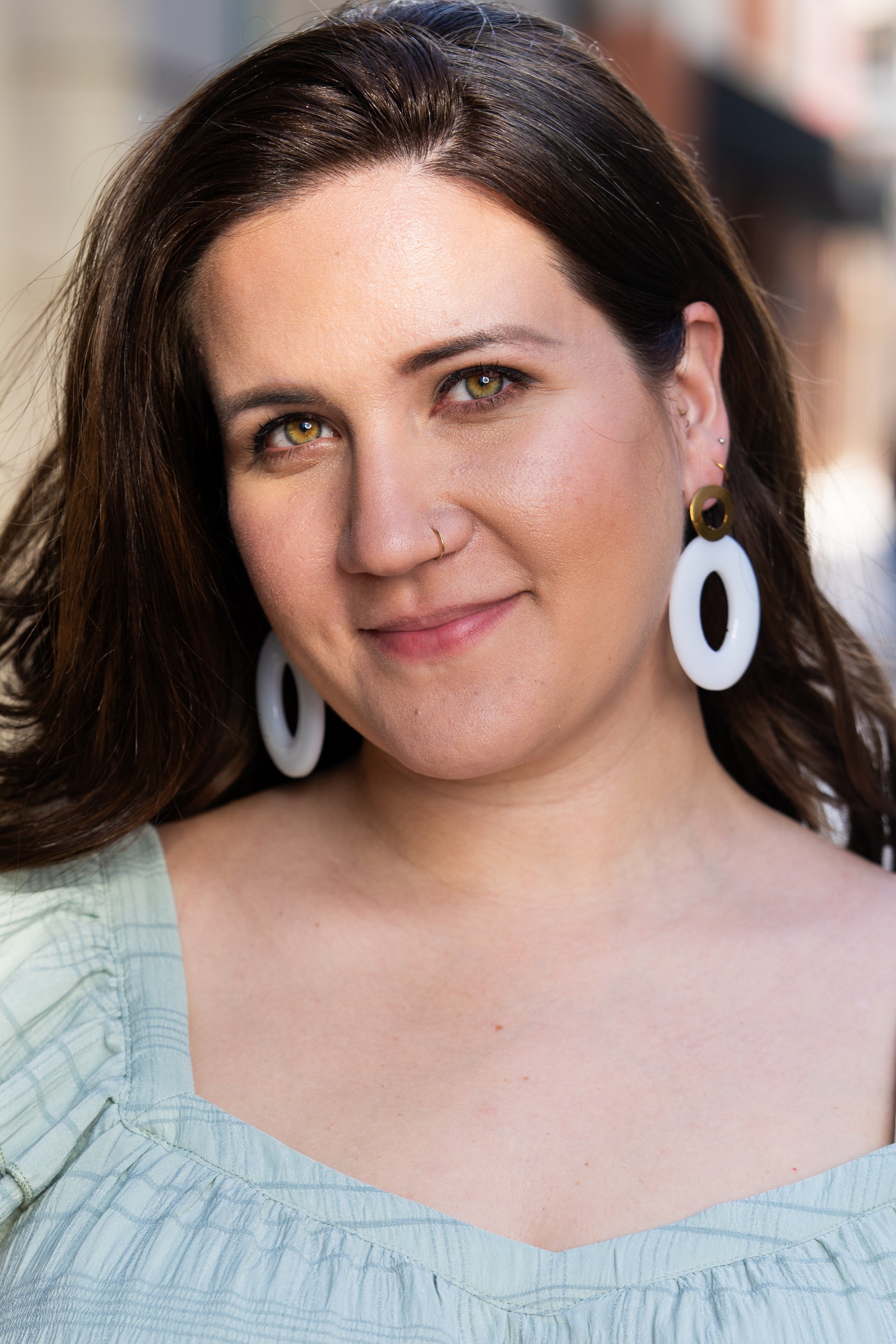 Woman wearing Sherami Collection white earrings, looking directly at the camera.
