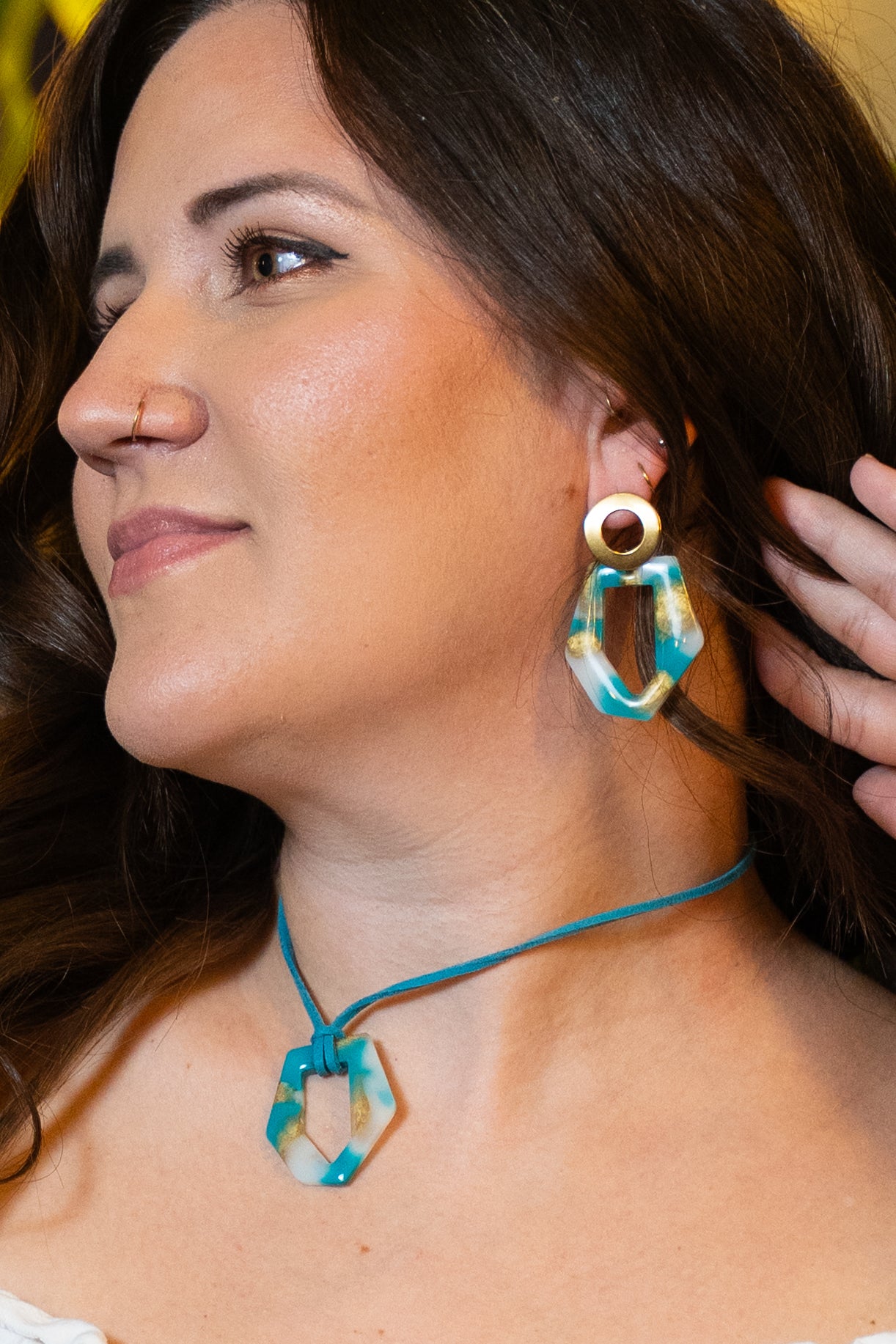 Woman wearing a colorful set earrings and necklace from Sherami Collection with a close-up of the jewelry.