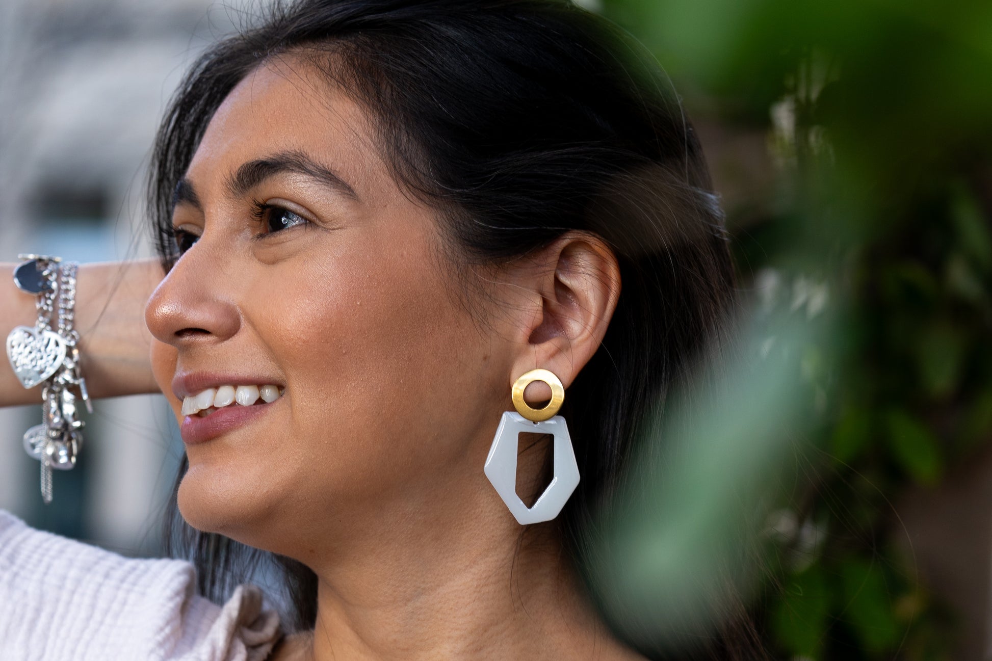 Close-up of a woman wearing a unique earring from Sherami Collection with a blurred background
