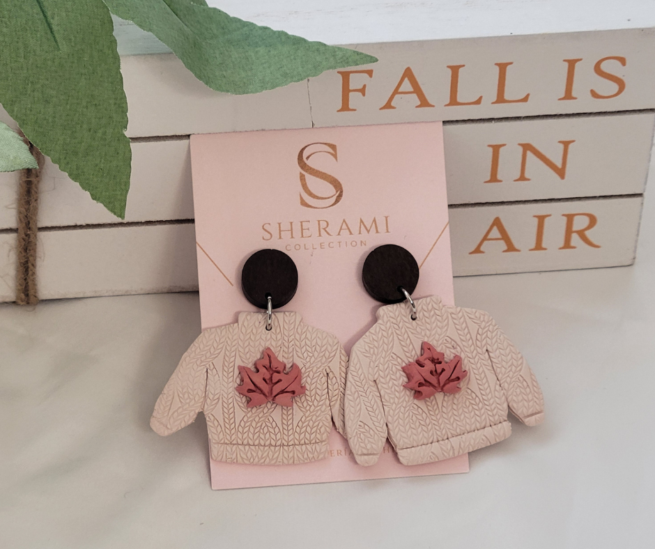 Aretes en forma de sueter sobre un esenario otoñal.
